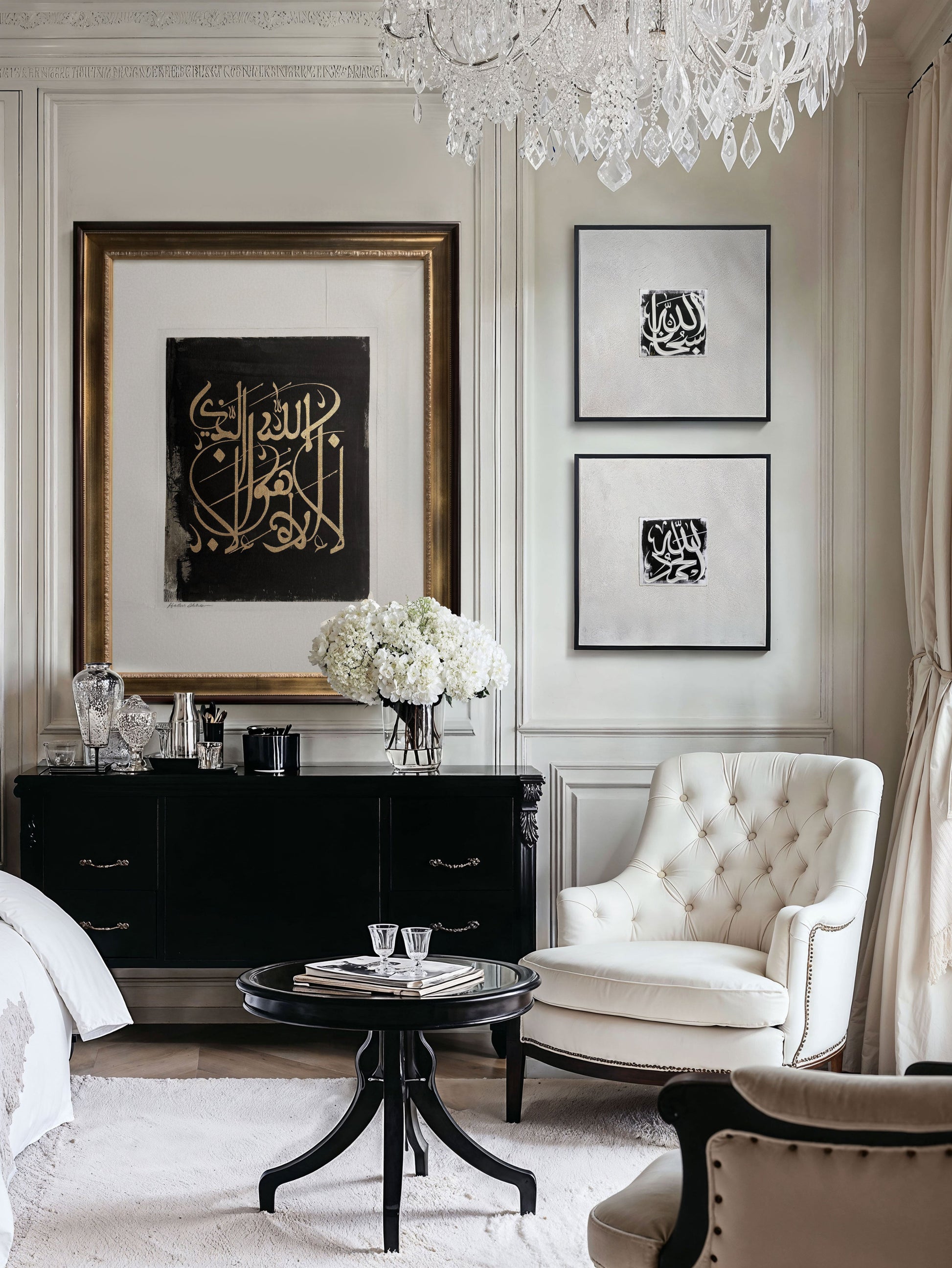 Elegant living room with framed gold hand painted Arabic calligraphy, white armchair, black sideboard, and chandelier.